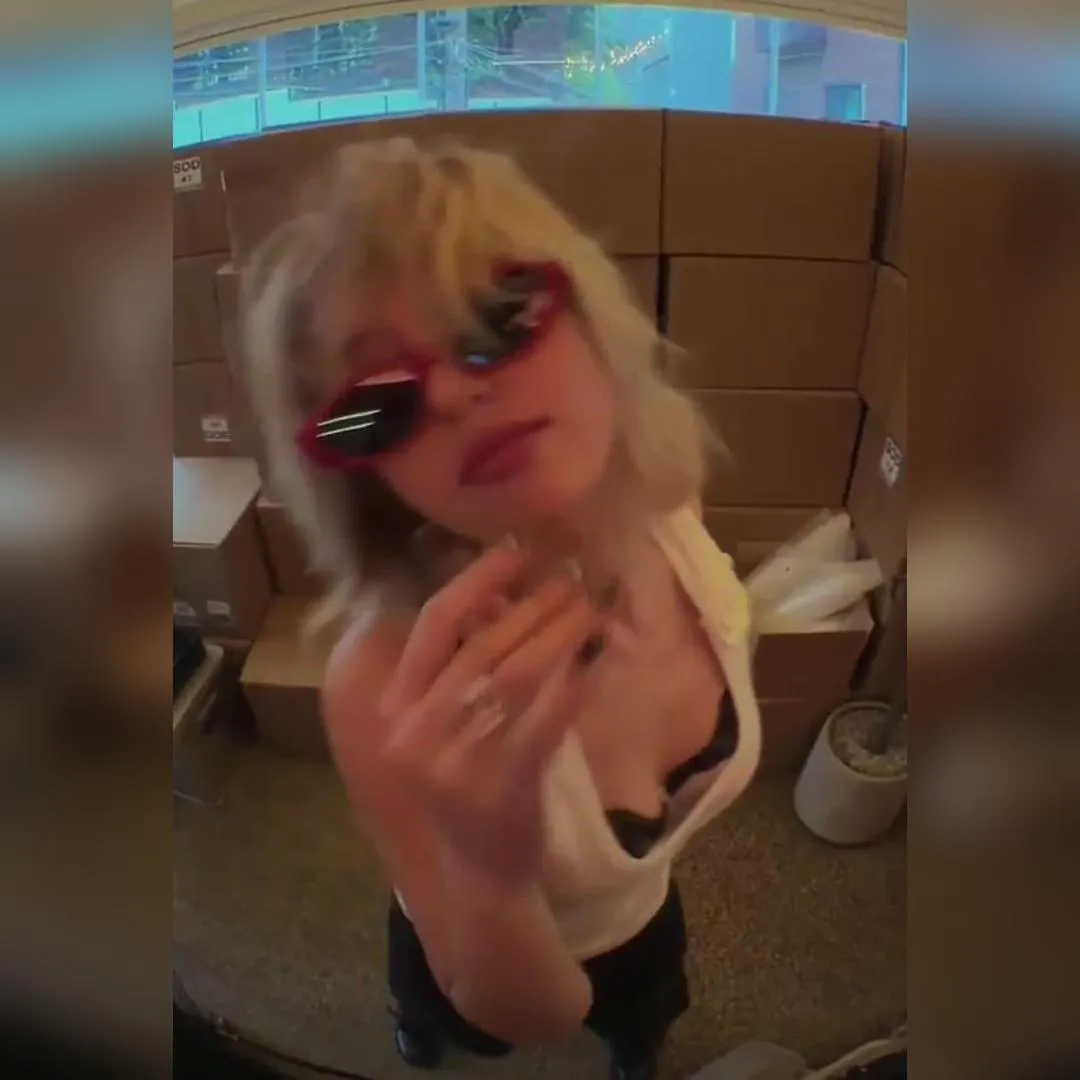 全昭彌穿白色露肩背心，低頭露出清晰胸溝