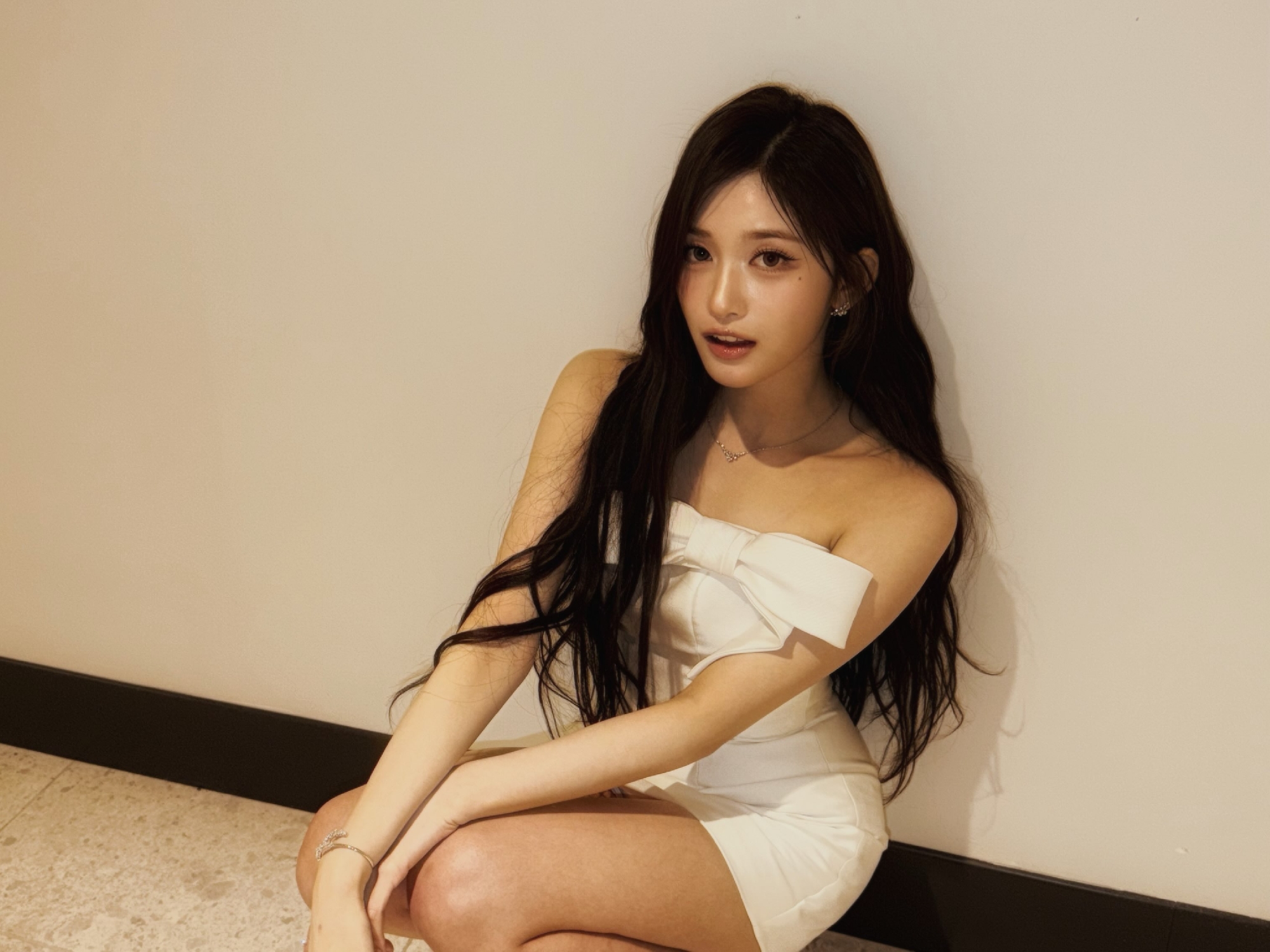 Lee Seo Teasing Thighs While Sitting Crouched in the Hallway Wearing a White Mini Dress