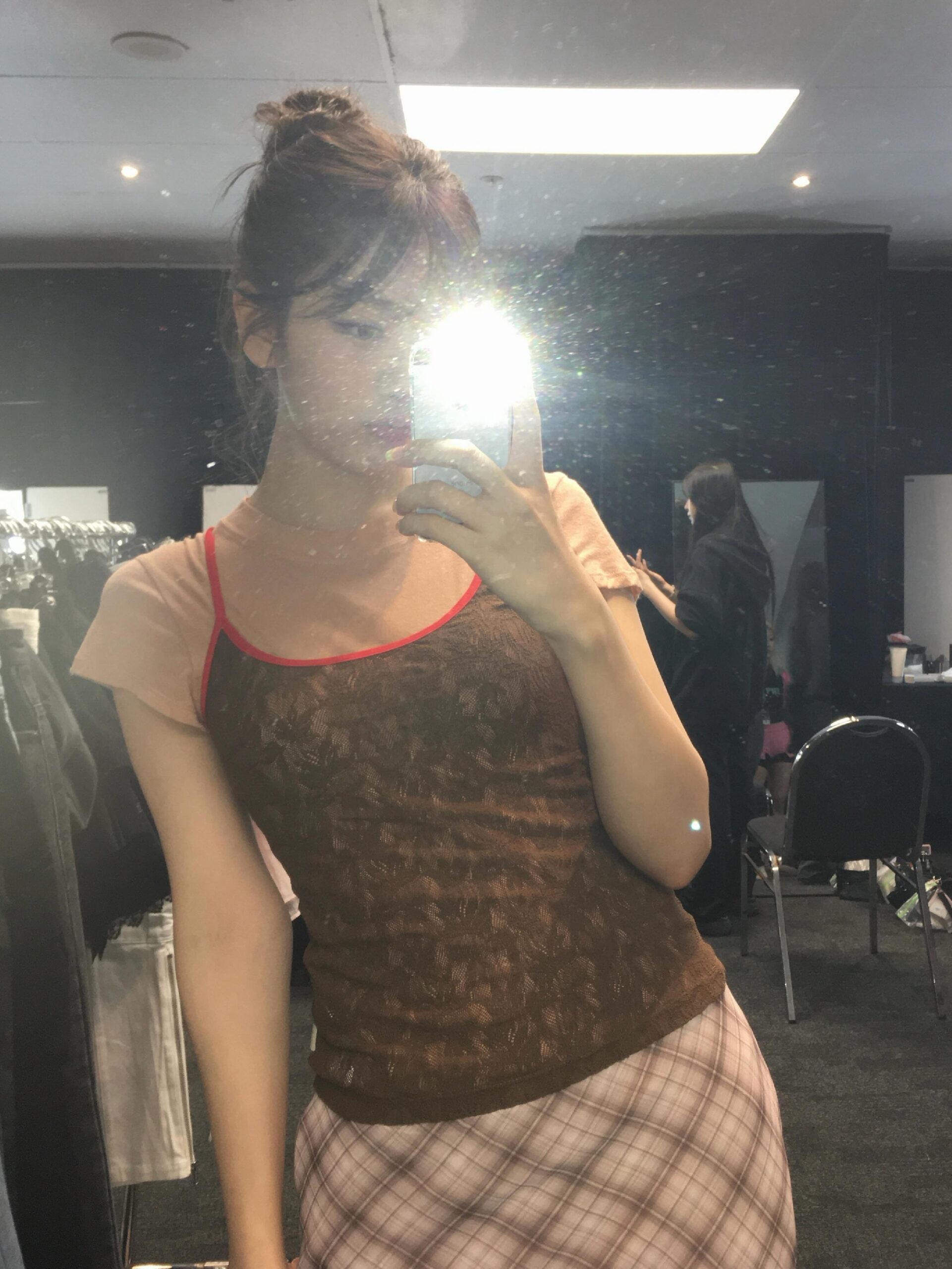 An Yujin seen with arms crossed, holding bubblegum and posing in a cute strappy camisole