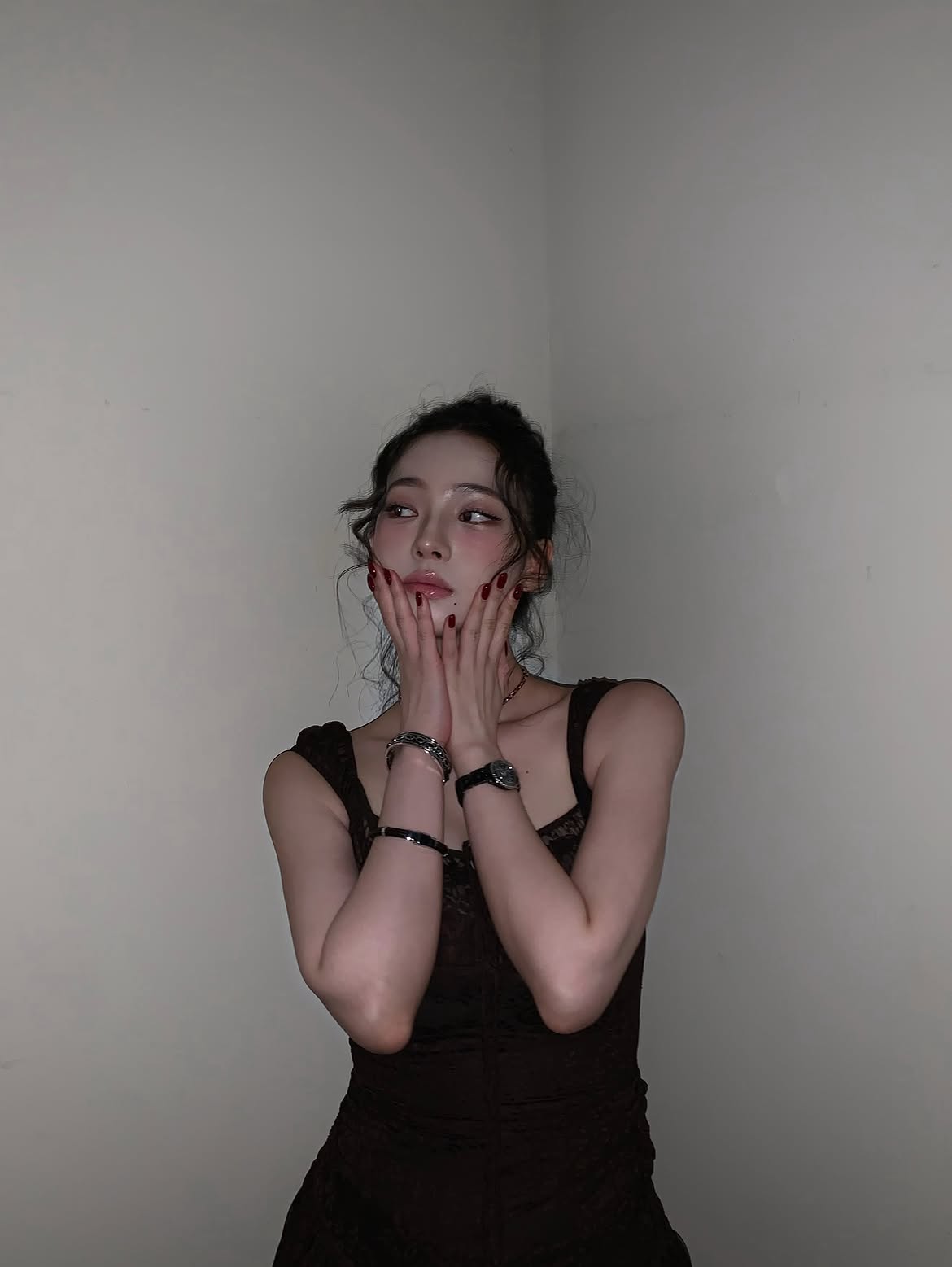Karina in a black sheer dress crouching down, chest area - Instagram