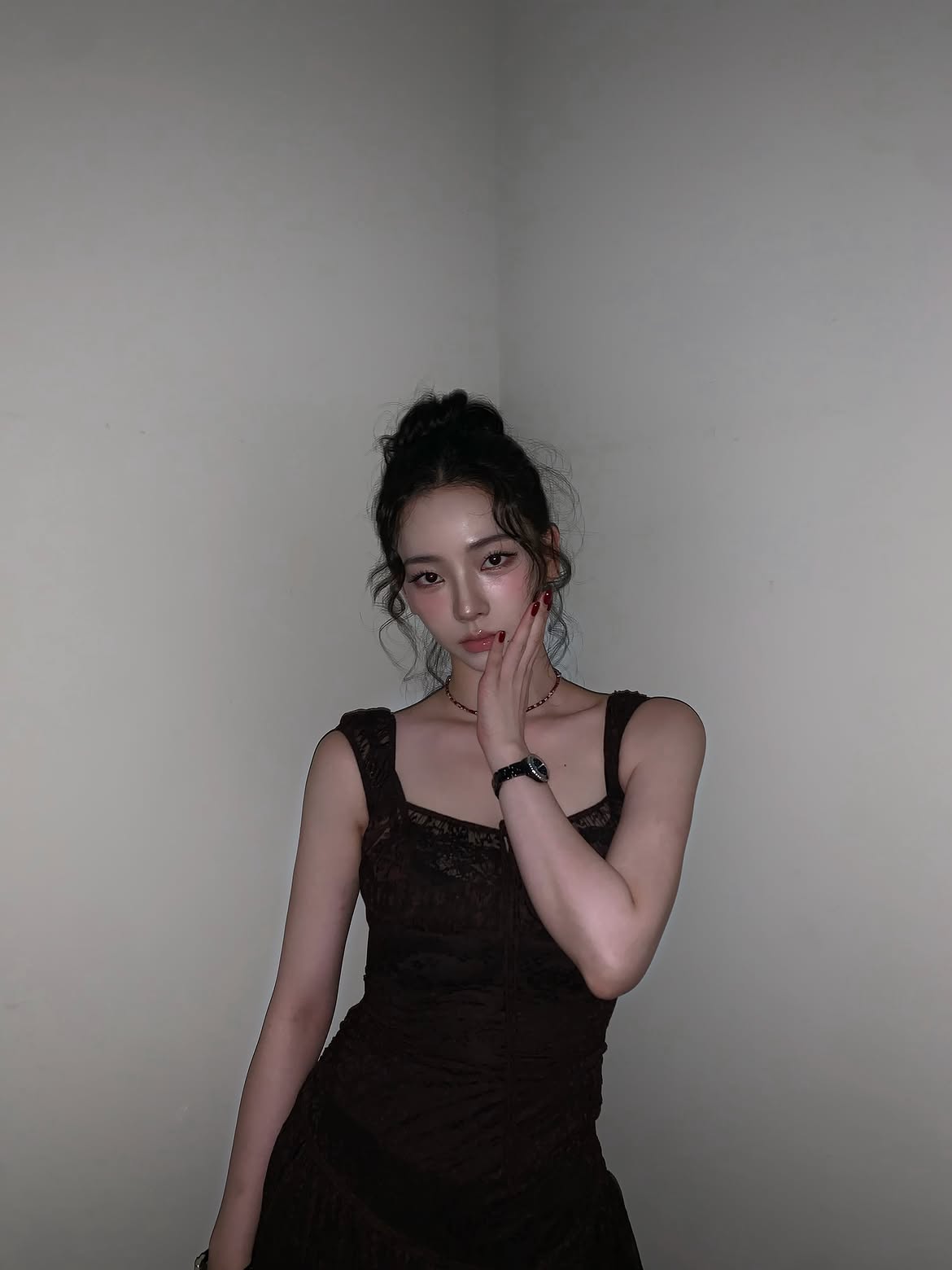 Karina in a black sheer dress crouching down, chest area - Instagram