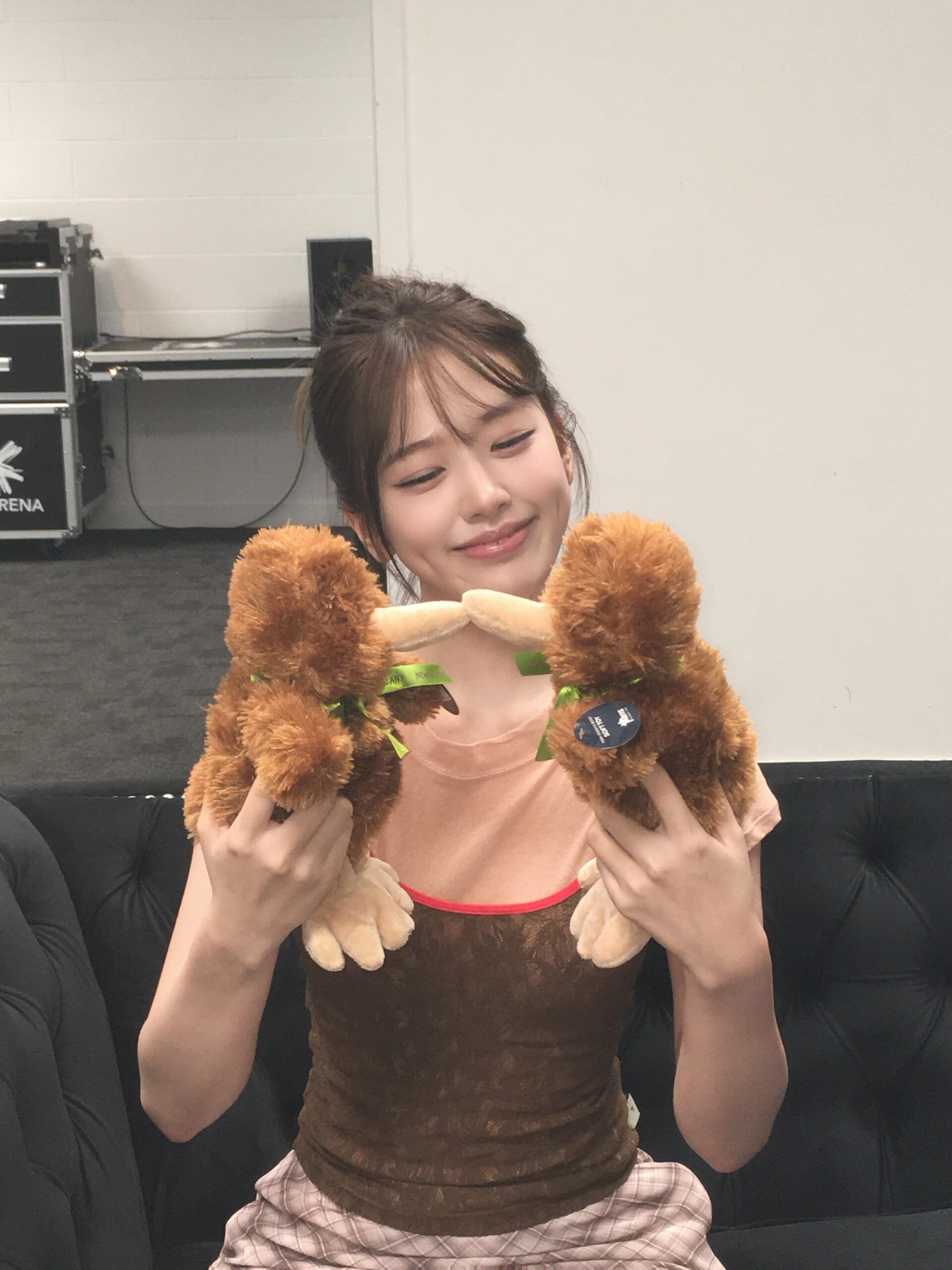 An Yujin seen with arms crossed, holding bubblegum and posing in a cute strappy camisole