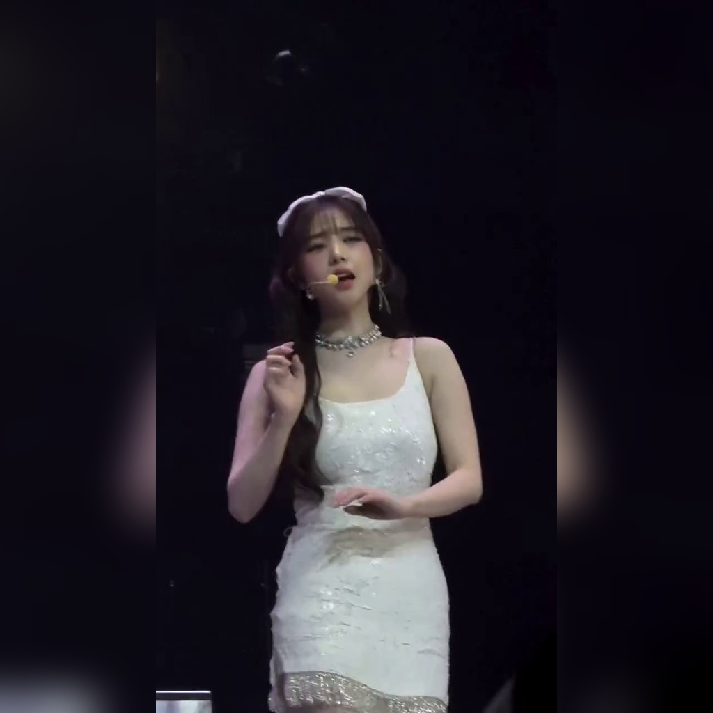 Karina in a white string dress sitting on the stage steps, heavy bust and thighs